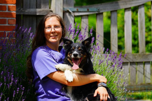 Dierenarts zit samen met hond buiten op een zonnige dag